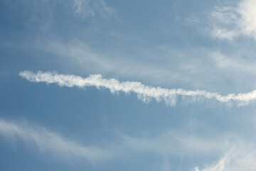 Naklejka na ściany i meble closeup of chemtrail on blue sky background