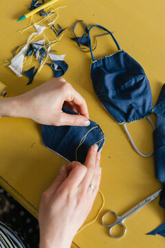 Woman hand sewing protection mask during COVID-19 pandemic
