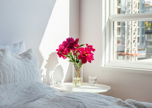 Bouquet of red peonies on bedside table