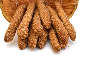 Baking bread with sesame stick isolated in basket on the white background