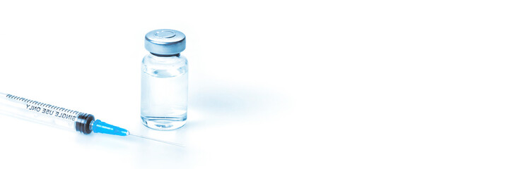 Medical syringe with a needle and a bollte with vaccine.