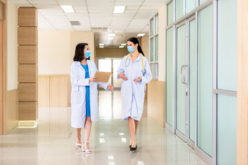 Obraz premium Group of medical staff discussing and report in hallway hospital. Healthcare professional taking and consoling