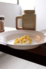 breakfast with a plate of scrambled eggs on a table and a cup of coffee behind the plate

