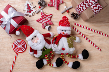 Obraz premium Christmas composition on wooden background with ribbons and gifts, Santa Claus and snowman. Top view.