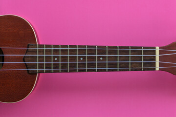 Obraz na płótnie Canvas Closeup shot of a ukulele headstock on a pink background