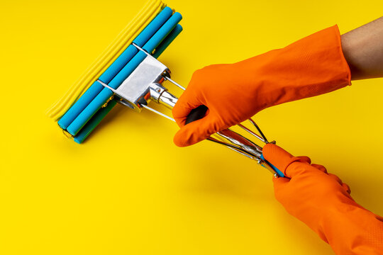 Sponge Mop And Other Cleaning Supplies Isolated On A Yellow Color Background. Above View. Studio Shot. Cleaning And Cleanup Concept