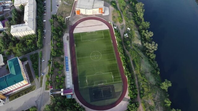 Football Field In The City. Sports Stadium For Running. A Very Long Shot. Aerial View Of A Drone Flying