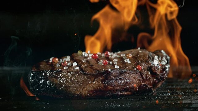 Close-up of tasty beef steak on iron cast grate, super slow motion, filmed on high speed cinematic camera at 1000 fps.