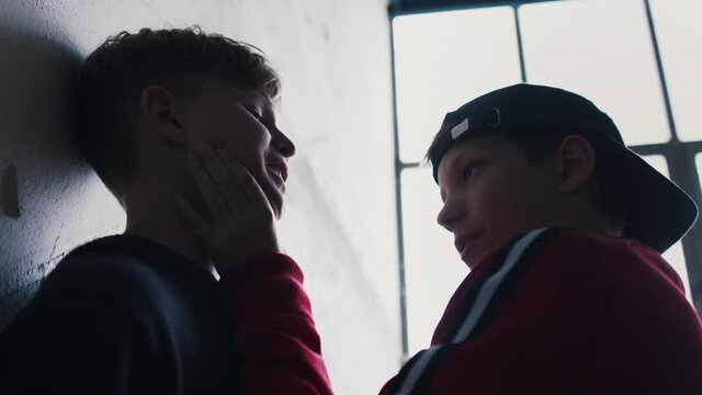 Teenage boy attacked by thug in abandoned building, gang violence and bullying concept.