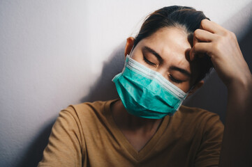 Depressed woman having headache after failure and layoff from work because impact from covid-19...