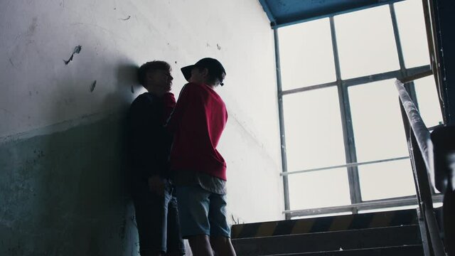 Teenage boy attacked by thug in abandoned building, gang violence and bullying concept.