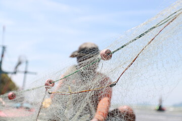 Hands fisherman take fish out of a net