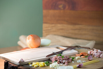pasta with carrot garlic onion bacon on a rustic tree board on a wooden table. showing the ingredients