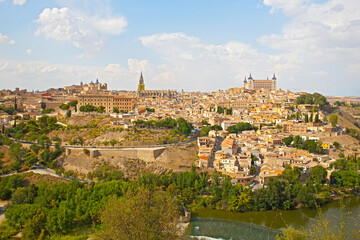 Fototapeta na wymiar Toledo city panorama, Spain. The historic city of Toledo with river Tajo under blue sky with cumulus clouds.