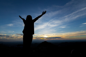 Fototapeta na wymiar Silhouette of asian woman raise her arms looking at the mountain and enjoy with beautiful nature with freshness and happiness