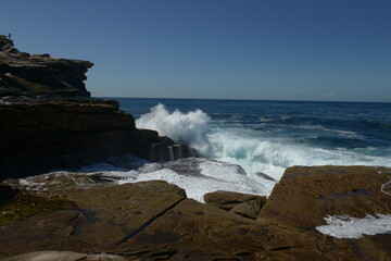 The rocks with the ocean and with the strongwomen waves near the Maroubra beach in Sydney, Australia