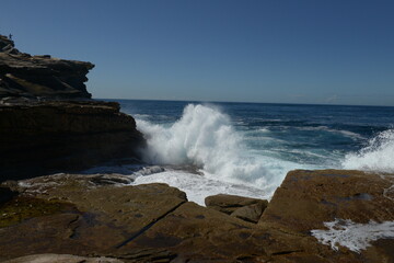 The rocks with the ocean and with the strongwomen waves near the Maroubra beach in Sydney, Australia