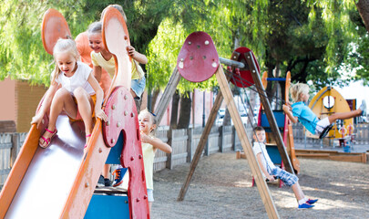 kids in school age playing together on playground outdoors