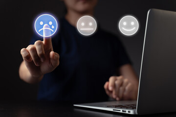 Woman using laptop and emoticon hologram effect.