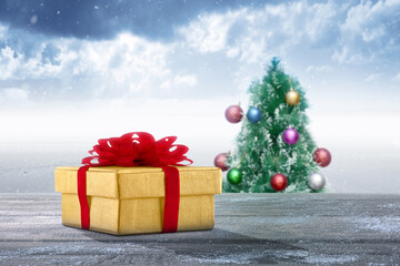 Gift box on a wooden table with a Christmas tree with a snowfall background