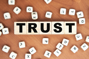 word concept written on a light table and light background. concept word TRAST on cubes on a...