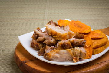 Porción de chicharron de cerdo y camote frito