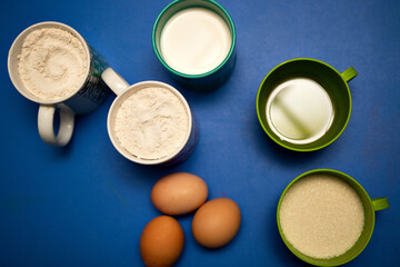 ingredients for a cake on blue background