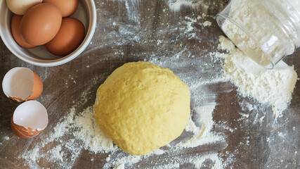 Kneading the Dough. On the table are flour, napkin, eggs and shells