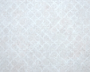 A flat surface of a light stone with an antique pattern applied.