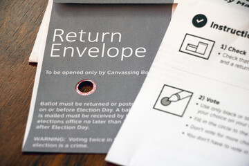 Ballot return envelope and instructions paper on table