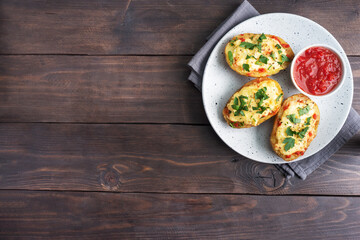 Baked potatoes in the peel stuffed with cheese with garlic and herbs. Copy space