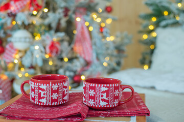 
cups with hot drink on the background of the christmas tree