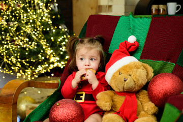 Fototapeta na wymiar Portrait of a cute baby in Christmas hat. Kid enjoy the holiday.