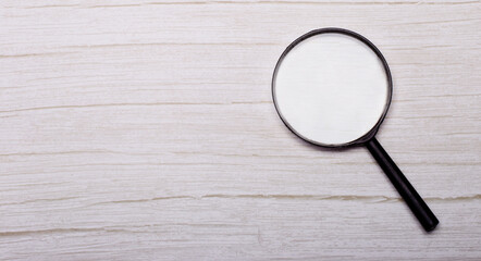 Magnifying glass or loupe on wooden table