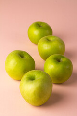 green apples on pink background.