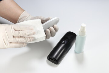 Cleaning staff clean wireless telephone in office with alcohol spray and wipe out with clean paper. Corona Virus or bacteria infected protection from touching public object. 