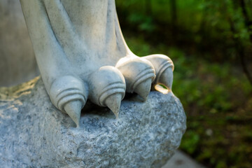 Fragment of paws and claws of a lion statue made of white marble