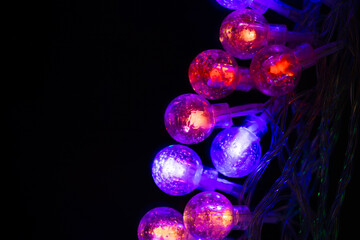 Beautiful Christmas garlands with led lights in glass balls on a black background