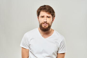 Obraz premium man in white t-shirt gesturing with his hands studio dissatisfaction lifestyle light background