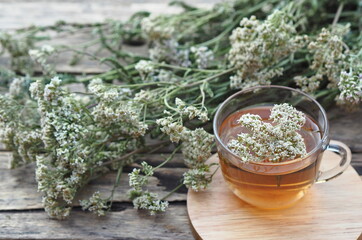 Herbal medicinal background.Healthy tea with yarrow flowers on a wooden rustic table. Place for text.