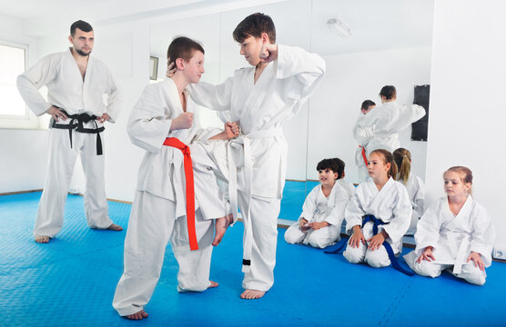 Pair of little boys practicing new karate moves during a class in gym