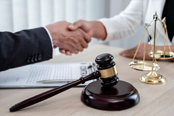 shake hand Professional male lawyers work at a law office There are scales, Scales of justice, judges gavel, and litigation documents. Concepts of law and justice