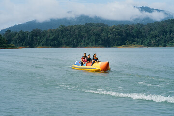 People enjoying water activities on banana boat at the Kenyir Lake, Terengganu, Malaysia.