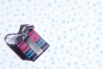 Fototapeta na wymiar Festive christmas card with gift on white background with blue drawn snowflakes, minimalism, copy space