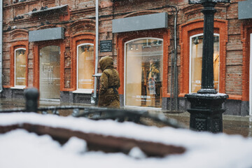 City street with shop window retail clothing store luxe brand, snowfall