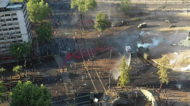 SANTIAGO, CHILE - OCTOBER 25, 2020 Hundreds of protesters fight against Chilean police in an attempt to obtain Baquedano Square hours after the end of the plebiscite