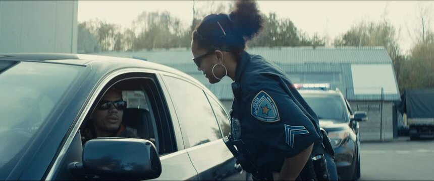 African-American Black Driver Is Being Pulled Off By Mixed-race Female Police Officer. Documents Check, Speeding Ticket. Shot On RED Cinema Camera With 2x Anamorphic Lens