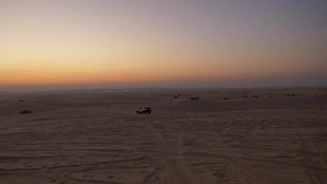 Cars dune bashing in the Saudi Arabian desert during sunset