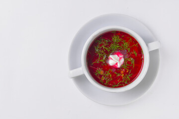 Ukrainian beetroot soup - borscht with sour cream served in a white bowl over white background.