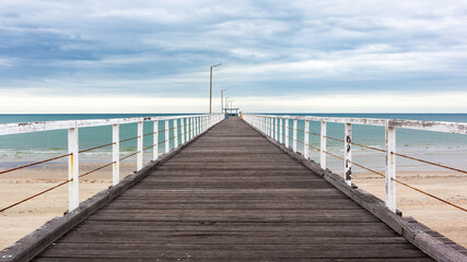 Fototapeta na wymiar The old largs bay jetty on an overcast day with no people in adelaide south australia on october 26th 2020